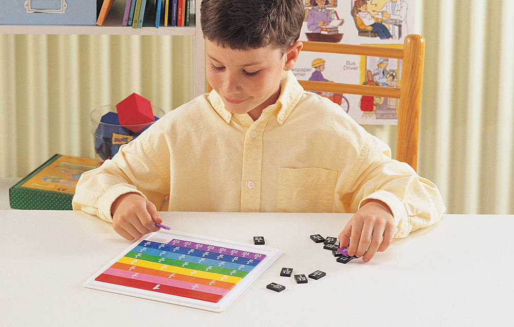 boy arranging colorful tiles on a board