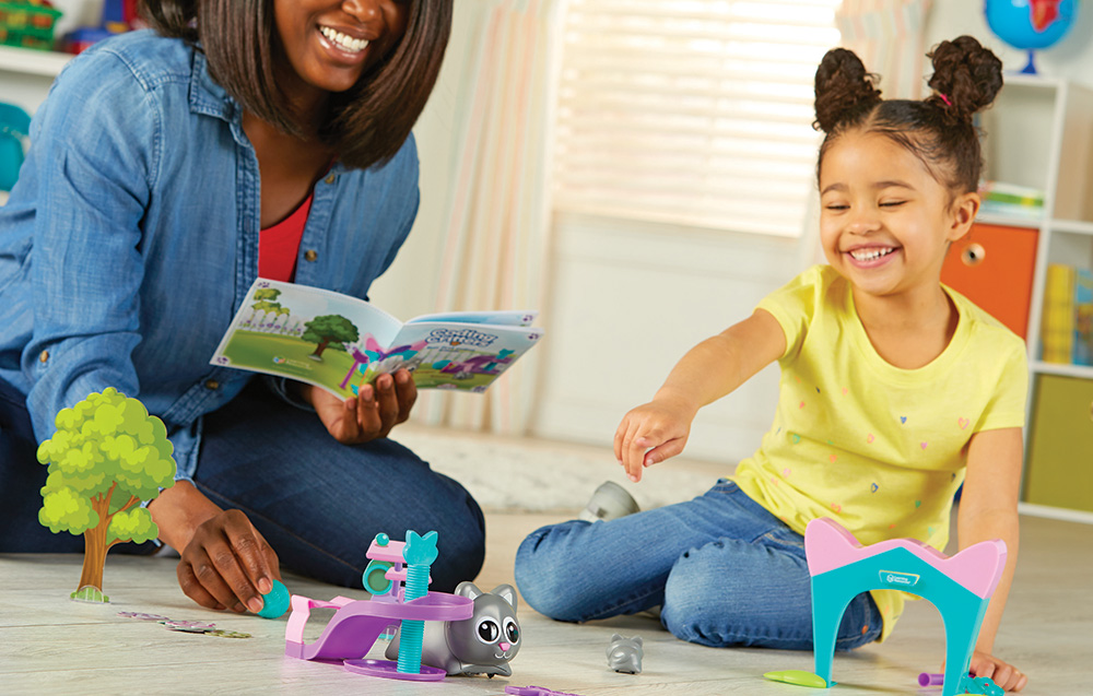 woman playing with her daughter with coding learning set